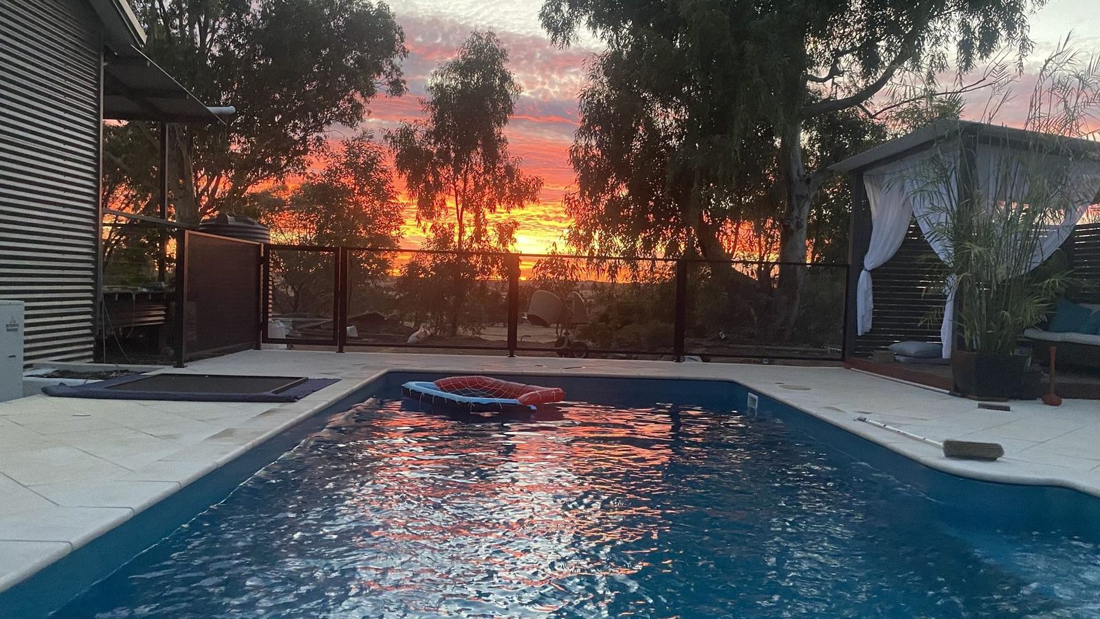 Pool Perf pool fencing around a backyard pool at sunset
